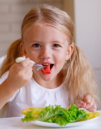 niña comiendo ensalada